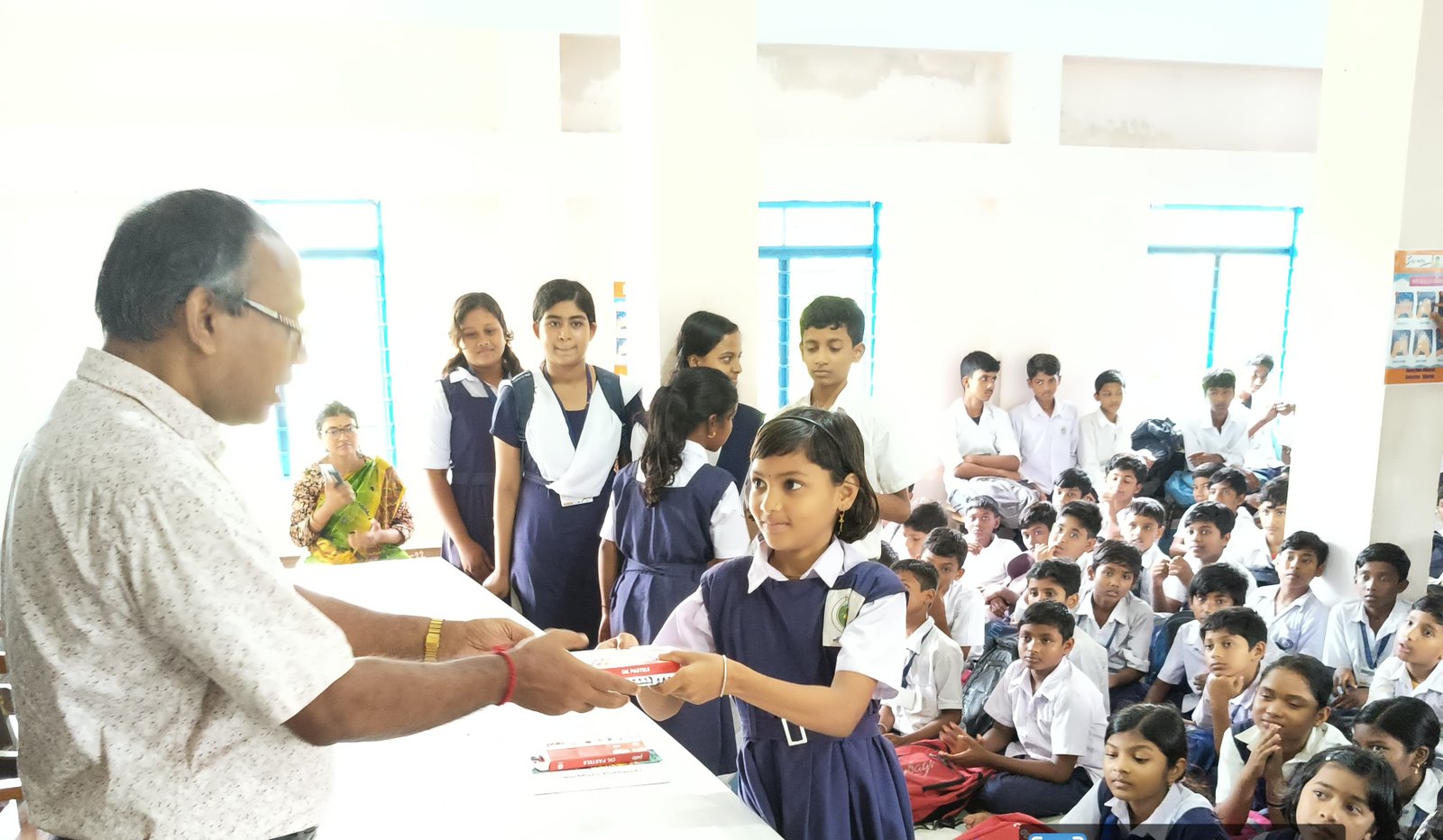 Students receiving books at a school programme